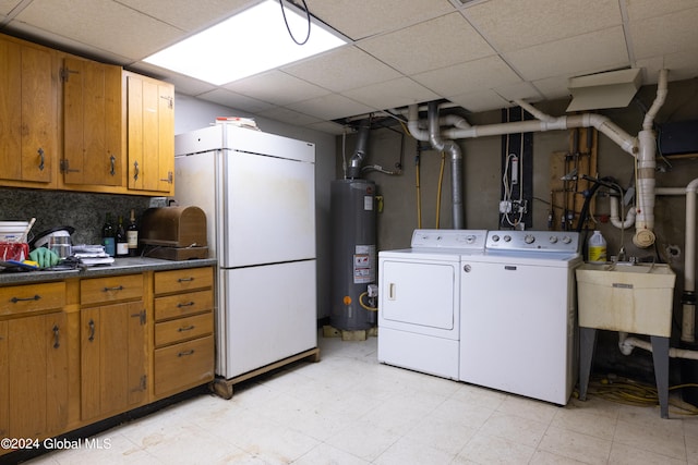 clothes washing area featuring gas water heater, light tile patterned flooring, separate washer and dryer, and cabinets