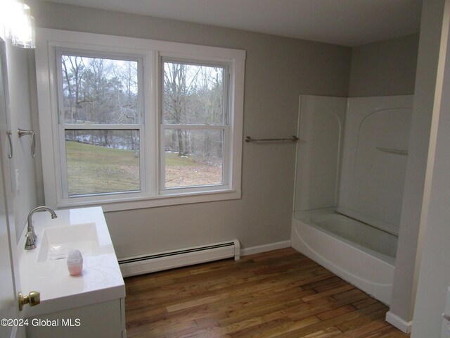 bathroom with vanity, a baseboard radiator,  shower combination, and wood-type flooring