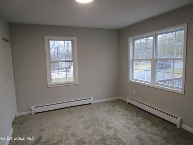 carpeted empty room featuring a baseboard radiator