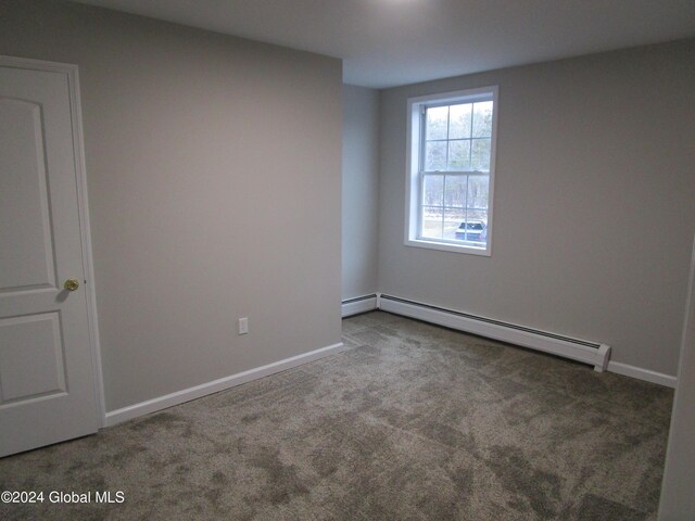 carpeted empty room with a baseboard radiator