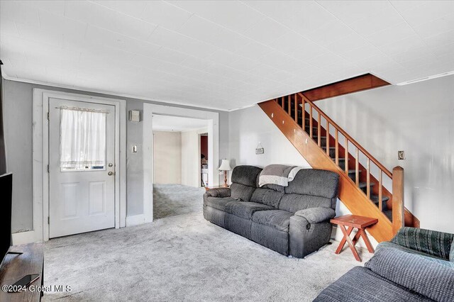 living area featuring carpet flooring and stairway