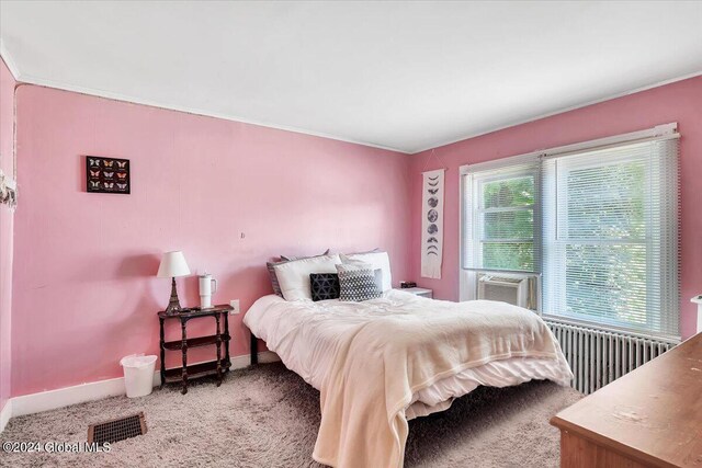 bedroom with visible vents, baseboards, radiator heating unit, cooling unit, and carpet flooring