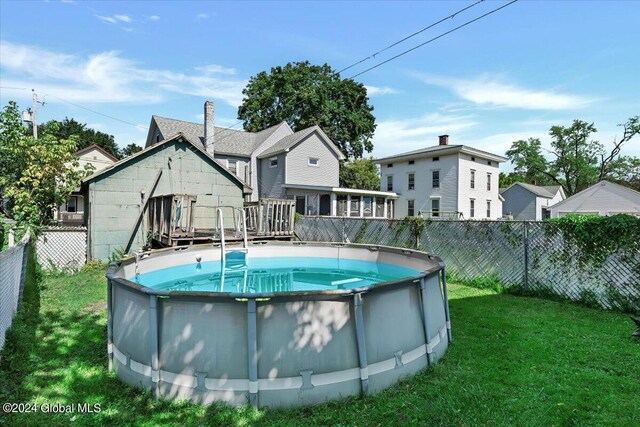 view of swimming pool featuring a yard, a fenced backyard, and a fenced in pool