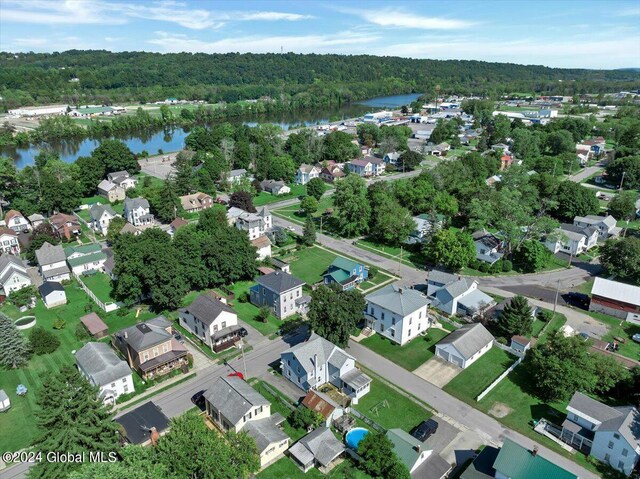 birds eye view of property with a water view, a wooded view, and a residential view