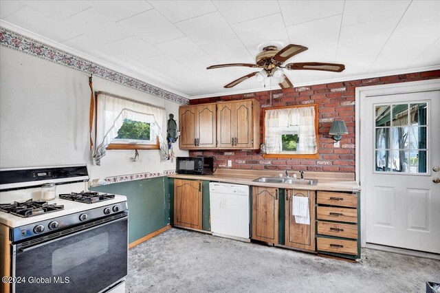 kitchen featuring black microwave, a sink, light countertops, dishwasher, and gas range