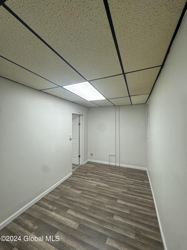 basement with wood-type flooring and a paneled ceiling