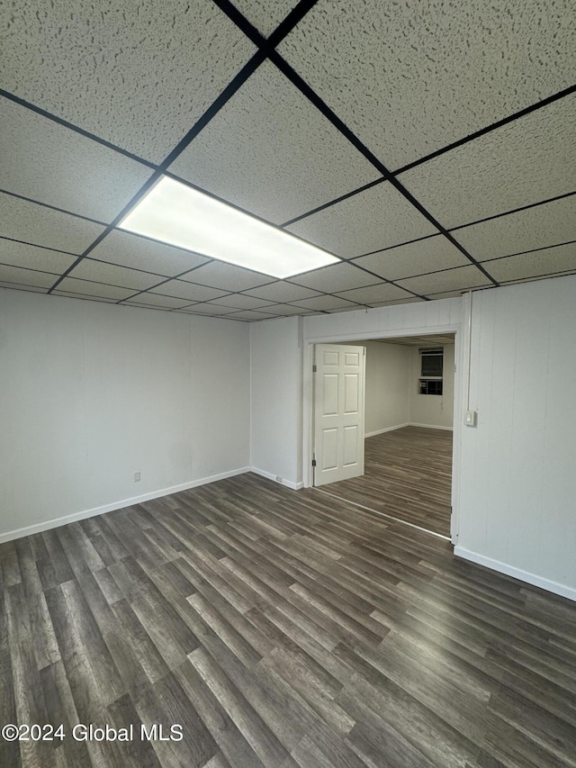 basement with a paneled ceiling and dark hardwood / wood-style floors