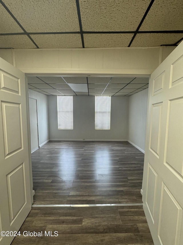 basement with a paneled ceiling and hardwood / wood-style flooring