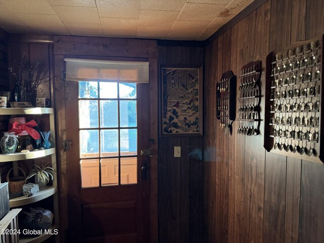 doorway to outside featuring wood walls