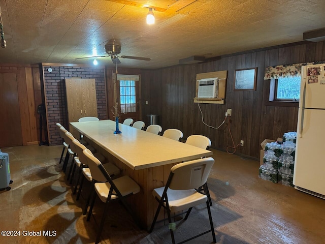 dining room featuring a wall mounted air conditioner and wood walls