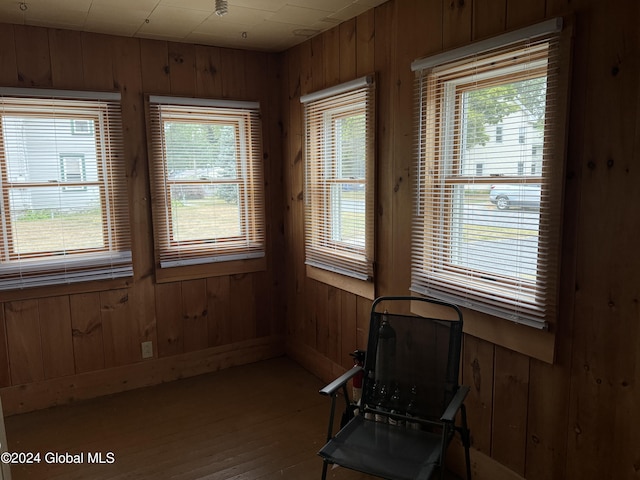 sitting room featuring wood finished floors and wooden walls