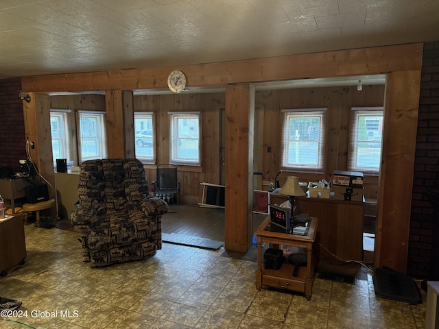 living room with plenty of natural light, wood walls, and tile patterned floors