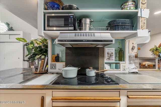 kitchen featuring black electric cooktop, cream cabinetry, and extractor fan