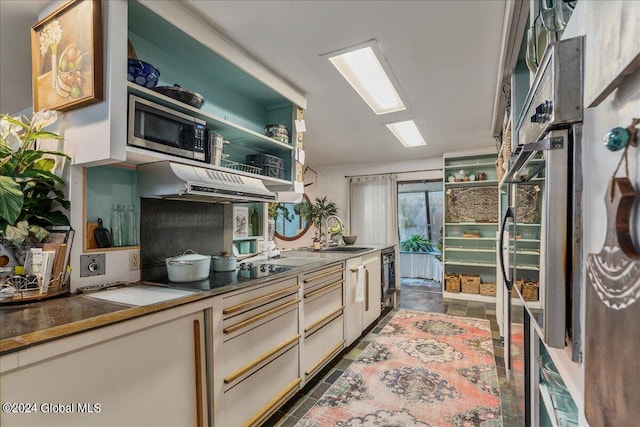 kitchen with exhaust hood, tile patterned flooring, sink, black cooktop, and stainless steel microwave