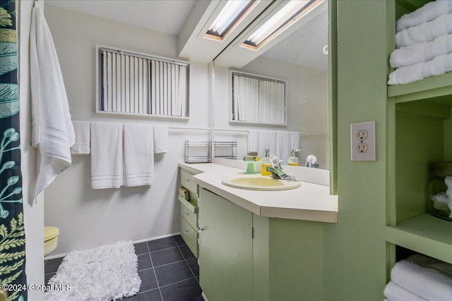 bathroom with tile patterned flooring, vanity, and toilet