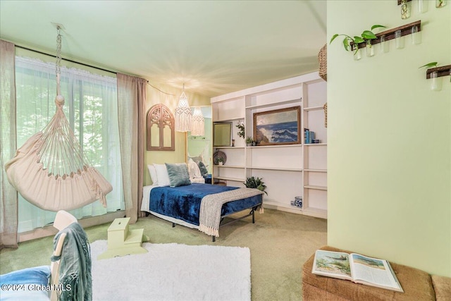 carpeted bedroom featuring an inviting chandelier