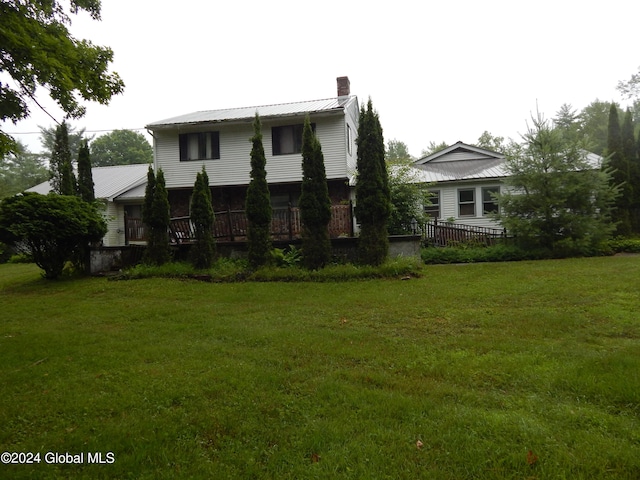 view of front of home with a wooden deck and a front lawn