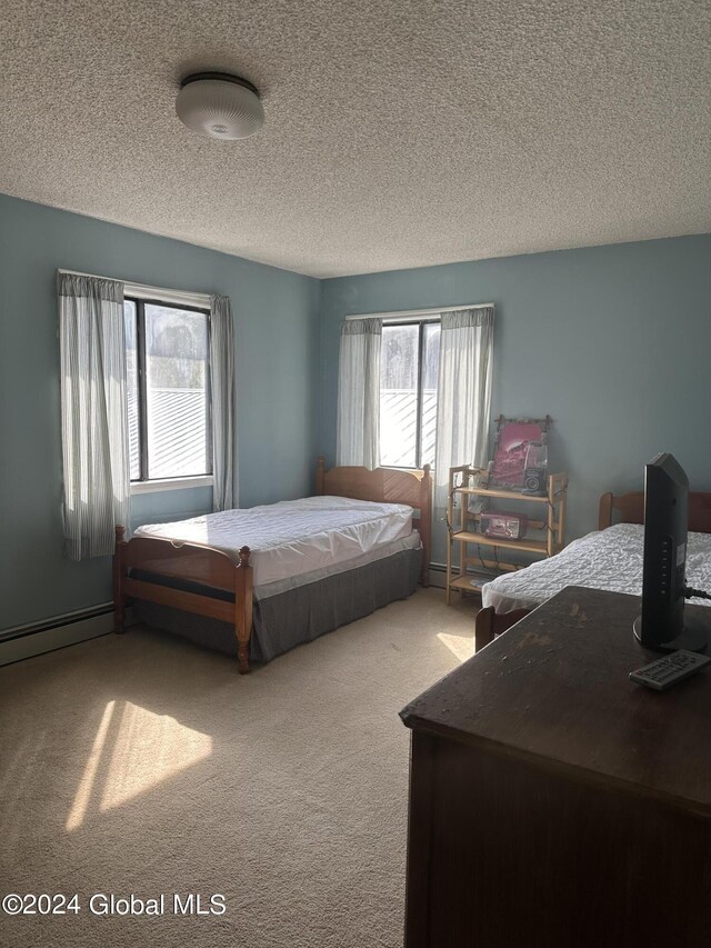 carpeted bedroom featuring multiple windows and a textured ceiling