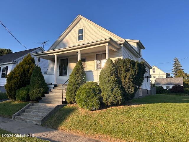 bungalow-style house featuring a front lawn and a porch