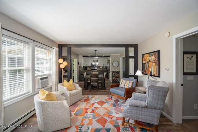 living room with cooling unit, a baseboard radiator, and hardwood / wood-style floors