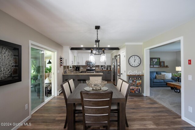 dining space with dark hardwood / wood-style floors, a chandelier, crown molding, and sink