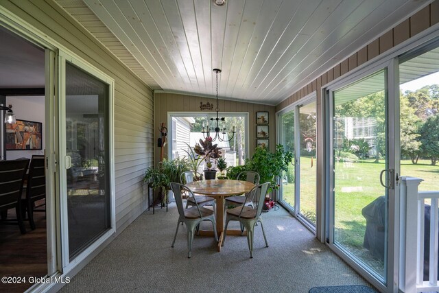 sunroom / solarium with vaulted ceiling, a notable chandelier, and wood ceiling