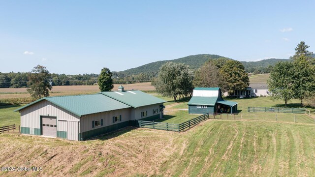 exterior space featuring an outbuilding, a mountain view, a rural view, and a garage