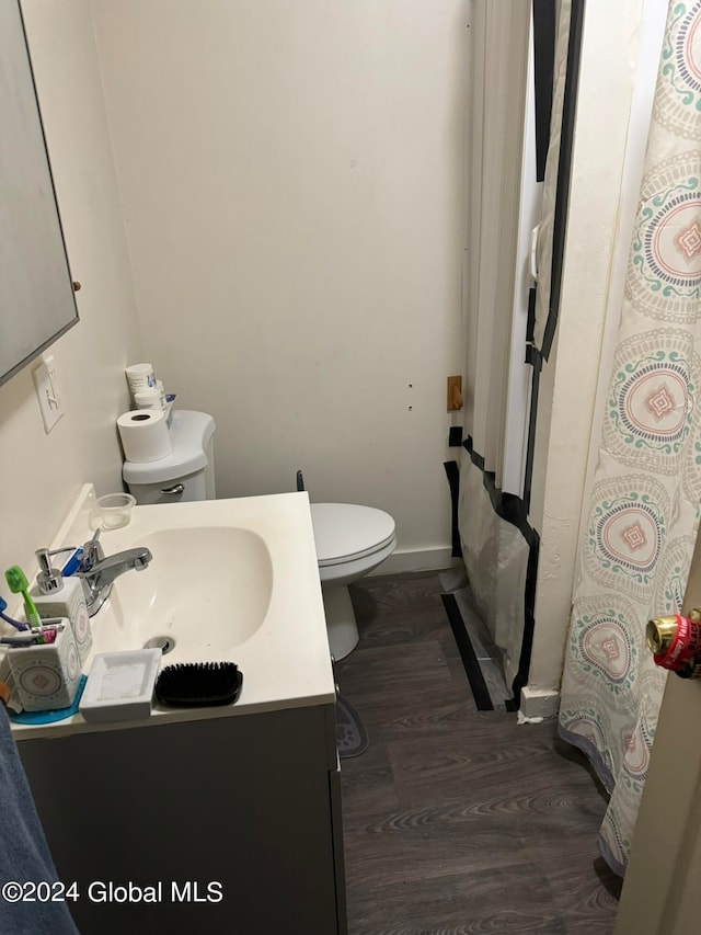 bathroom featuring toilet, hardwood / wood-style floors, vanity, and a shower with shower curtain