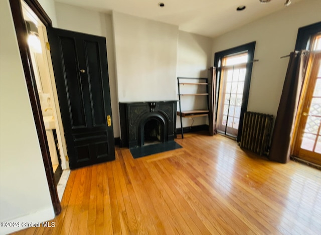 unfurnished living room with radiator and light hardwood / wood-style floors