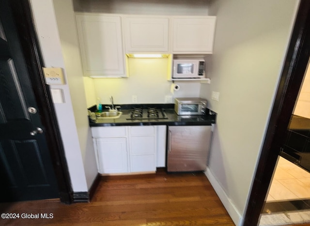 kitchen with dark wood-type flooring, sink, and white cabinetry