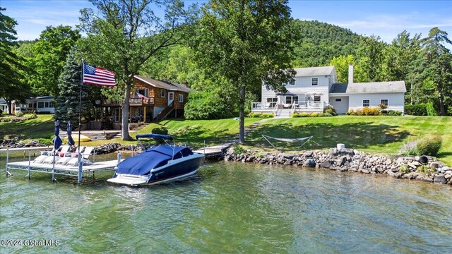 view of dock featuring a yard and a deck with water view