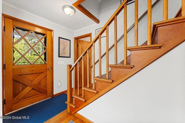 entryway featuring hardwood / wood-style flooring and ornamental molding