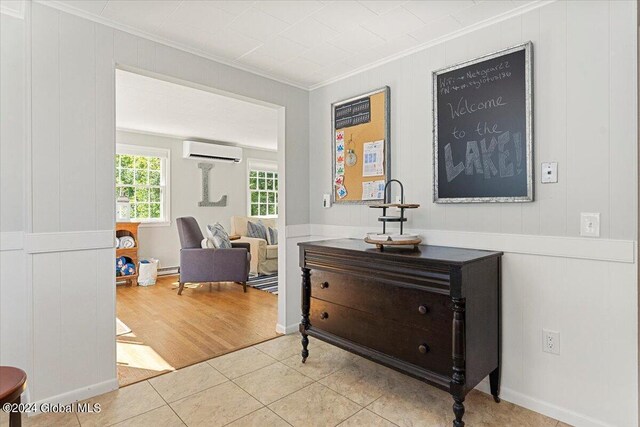 hall with crown molding, light hardwood / wood-style flooring, and a wall unit AC