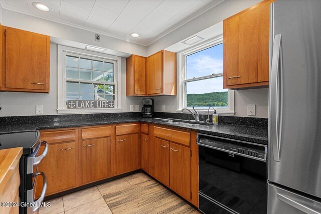 kitchen featuring appliances with stainless steel finishes, plenty of natural light, ornamental molding, and light tile patterned flooring