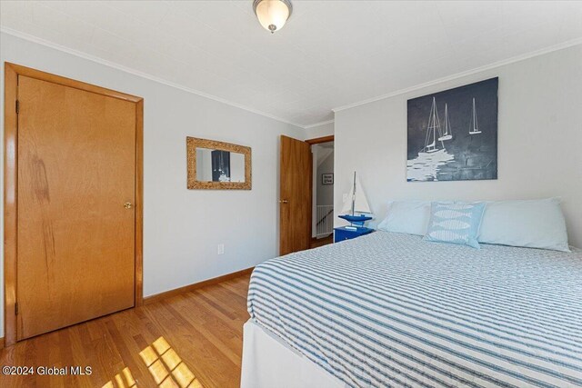 bedroom featuring ornamental molding and light hardwood / wood-style floors