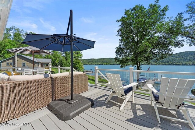 wooden terrace with an outdoor living space and a water view