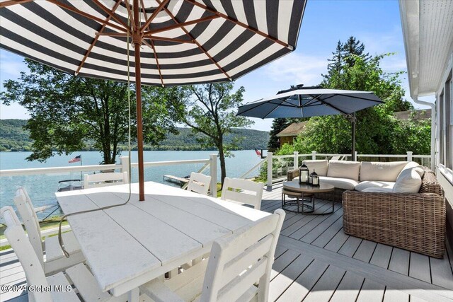 wooden deck with outdoor lounge area and a water view