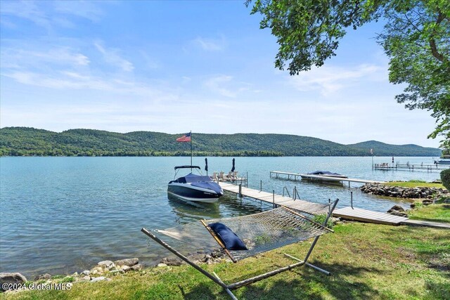 view of dock with a water and mountain view