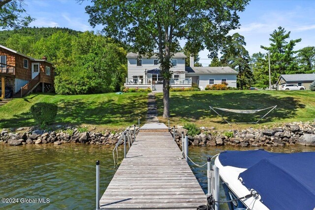 dock area with a water view and a lawn