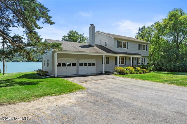 view of property featuring a garage and a front lawn