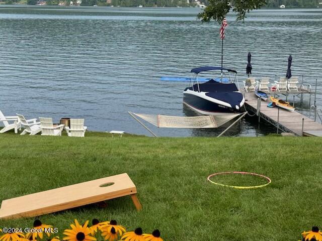 view of dock featuring a water view and a yard