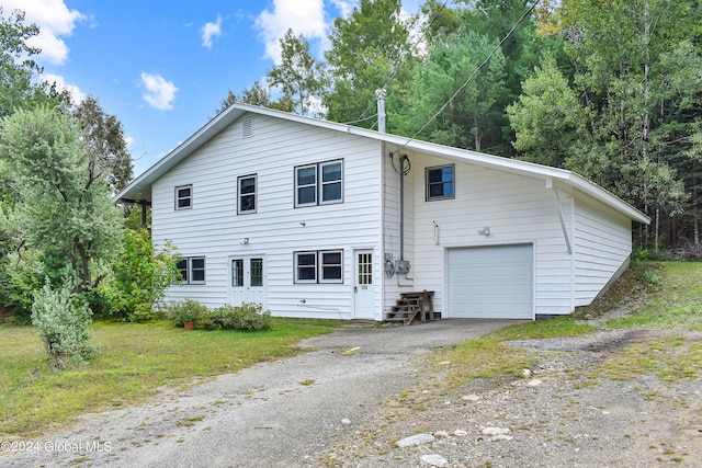 view of front of property with a garage and a front lawn