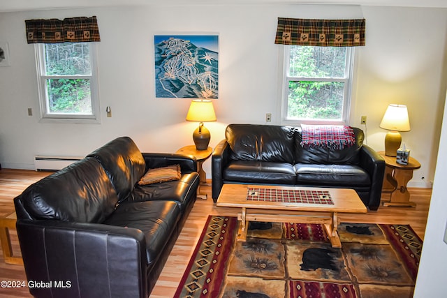 living room featuring hardwood / wood-style flooring, plenty of natural light, and a baseboard heating unit