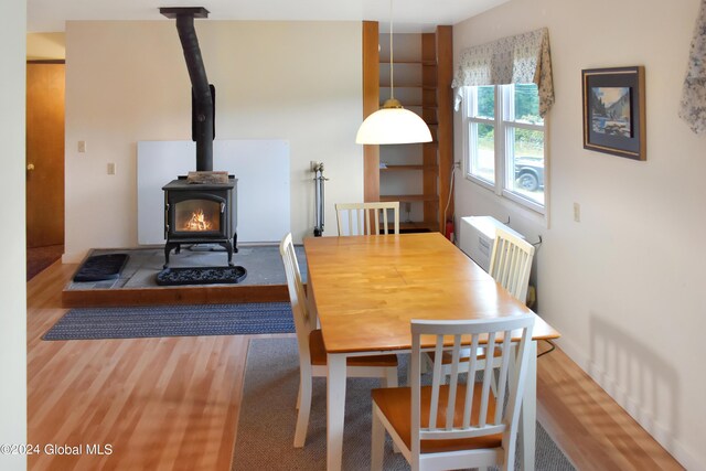 dining room with a wood stove and hardwood / wood-style floors