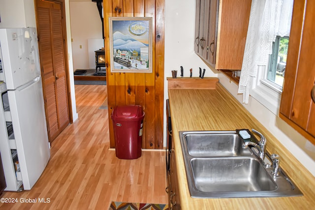 kitchen with white fridge, sink, and light hardwood / wood-style floors