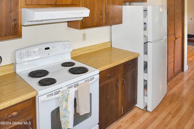 kitchen featuring white appliances, range hood, and light hardwood / wood-style flooring