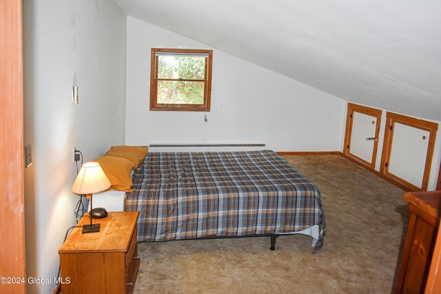 carpeted bedroom with vaulted ceiling and baseboard heating