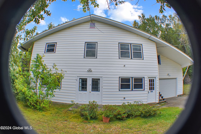 back of house featuring a yard and a garage