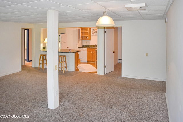 interior space featuring light colored carpet, sink, white fridge, and a baseboard heating unit