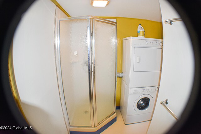 clothes washing area featuring stacked washer and clothes dryer